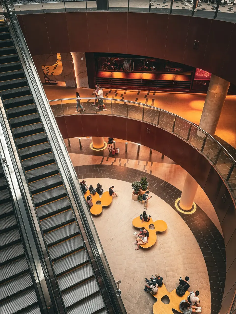 A group of people sitting at tables on top of an escalator